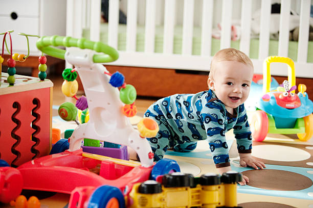 Baby crawling with toys Baby crawling and smiling, toys, crib baby toys stock pictures, royalty-free photos & images