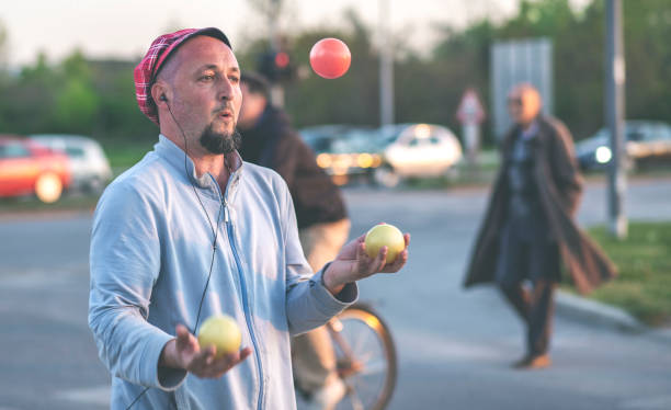 Juggler man performing at the traffic lights, after the presentation he asks the drivers for a donation.