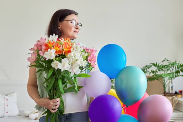 anniversaire, 45 ans, femme heureuse avec bouquet de fleurs et de ballons - 45 49 years photos et images de collection