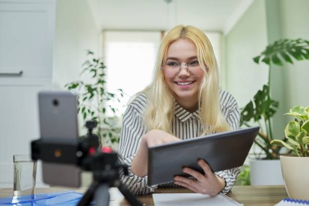 istock Female teenager student talking looking at smartphone webcam using digital tablet 1326973110