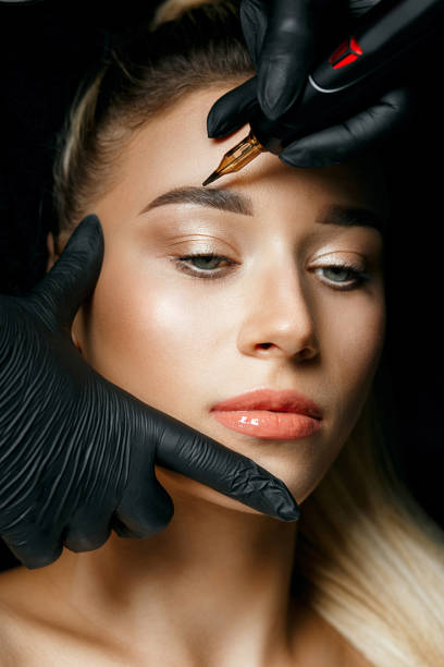 istock Cosmetician in gloves doing permanent makeup 1326973119
