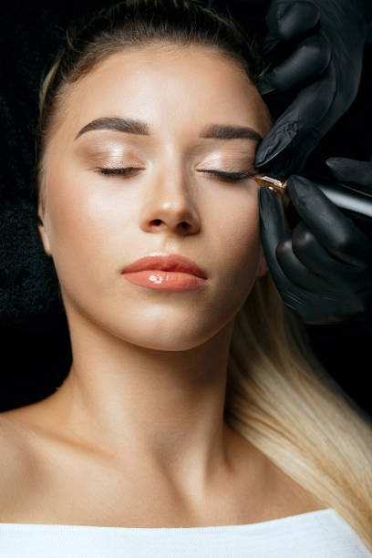 istock Makeup artist in gloves applying permanent makeup 1326973130