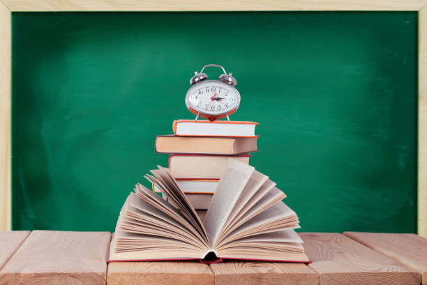 istock Open book with silver watch on the stack of books 1326974478
