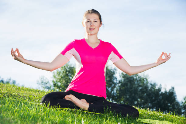 female 20-30 years old in pink t-shirt is sitting and meditating - women spain 20 25 years adult imagens e fotografias de stock