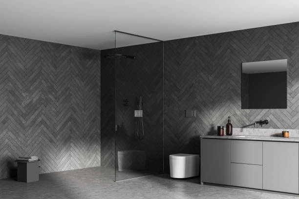 istock Spacious modern bathroom design interior in gray tones with cement floor, walk-in shower, sink vanity. Window light. 1326977169
