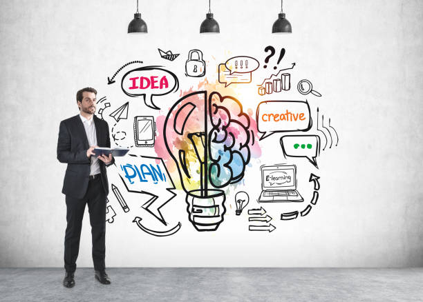 istock Businessman with notebook, light bulb a grey concrete wall 1326978145