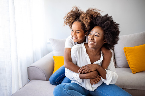 Closeup photo of cute small girl young charming mommy hugging holding each other close piggyback sitting comfy sofa spend free time together home house indoors