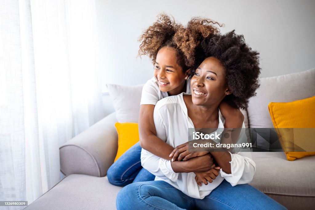 Closeup photo of cute small girl young charming mommy hugging holding each other close piggyback Closeup photo of cute small girl young charming mommy hugging holding each other close piggyback sitting comfy sofa spend free time together home house indoors Mother Stock Photo