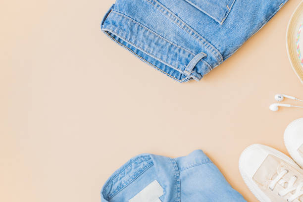 istock Flat lay summer composition with a straw hat, jeans and sneakers on a yellow background 1326981392