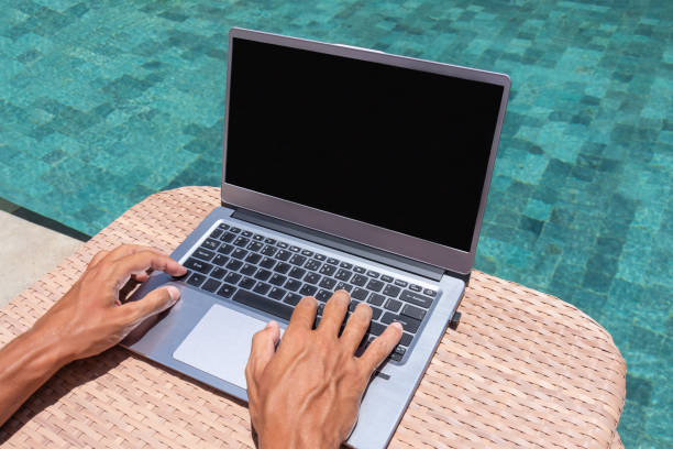 istock Fingers are typing on a laptop. Freelance by the pool. 1326983653