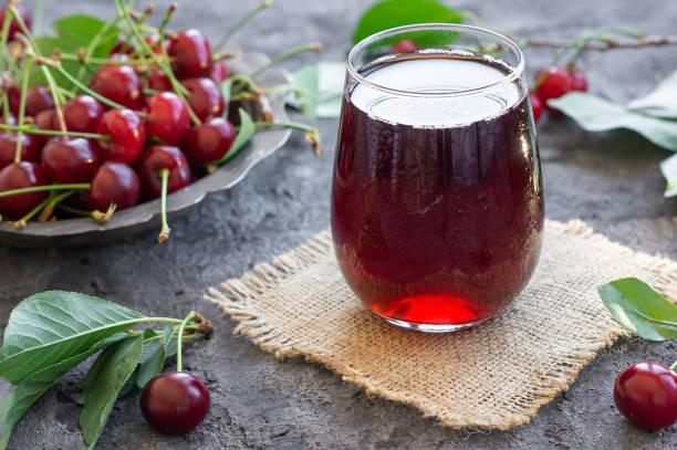 Glass of sour cherry juice with fresh red cherries, summer juice stock photo