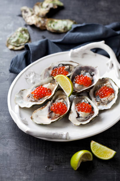 istock Fresh oysters, garnished with red caviar and lime 1326988270