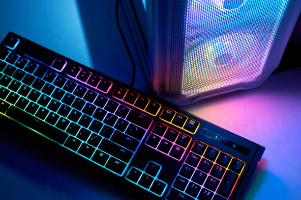 istock Backlit keyboard and a gaming PC with led lights on the computer. LED RGB lighting cooling fans for PC. Concept of gaming or eSports 1326989307