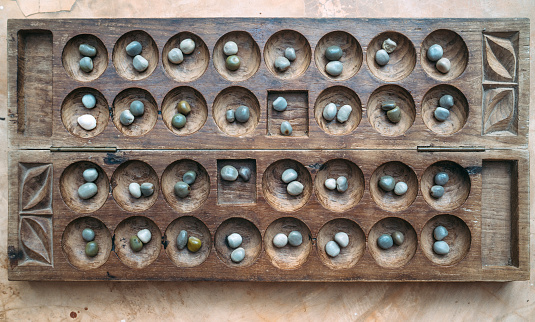 Antique Boa Mancala tradition African Board Game. Vintage Bao carved wooden Board Game. With natural baobab tree seeds Balls.