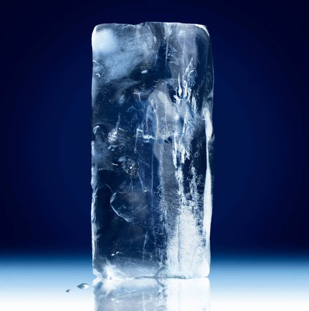 istock Vertical rectangular block of ice isolated on dark blue background with clipping path. 1326991213