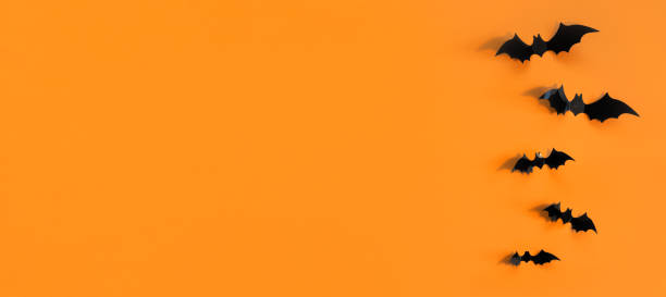istock Halloween card with black bats on orange background. Banner for congratulations or invitation. 1326993476