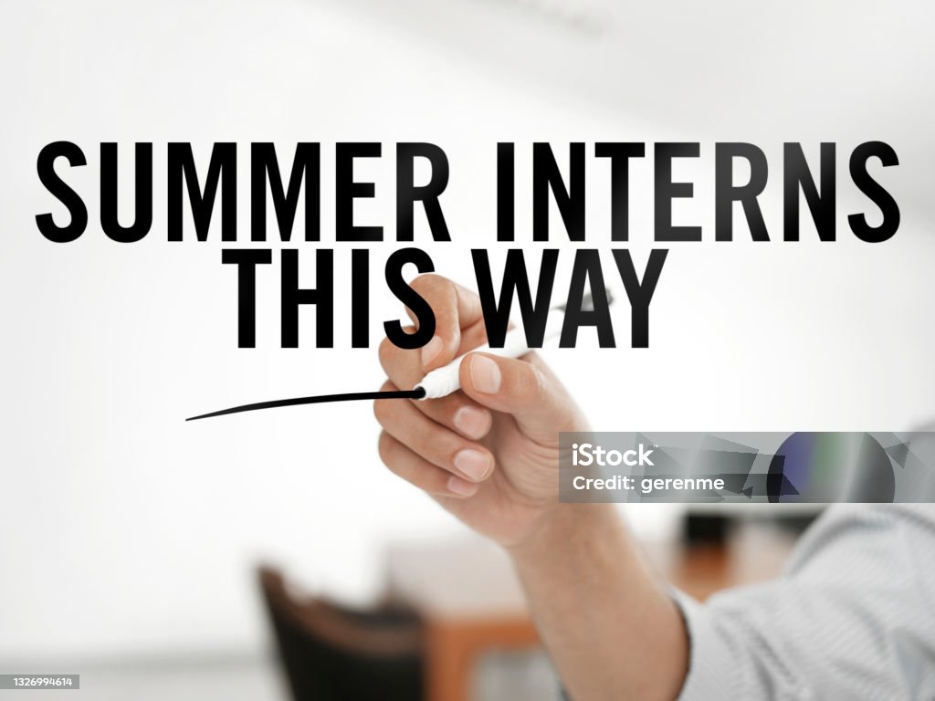 Summer interns this way Man writing "Summer interns this way" on a transparent board Trainee Stock Photo