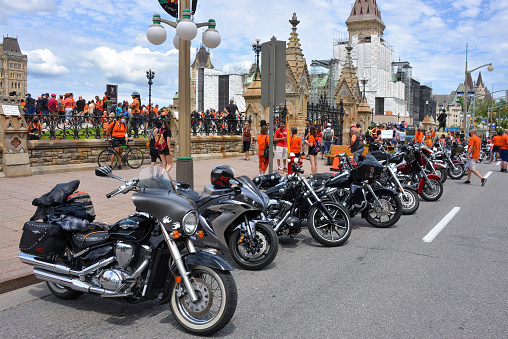 Ottawa, Canada - July 1, 2021: A row of motorcycles in front of Parliament Hill during the Cancel Canada Day rally. They believe it is not proper to celebrate Canada Day in light of the recent discovery of unmarked graves on residential school grounds.