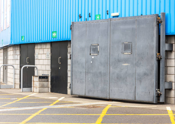 Dublin, Ireland - May 5, 2012: A man walking past large entrance gates to the St. James's Gate Brewery in Dublin, where Guinness has been made since 1759.