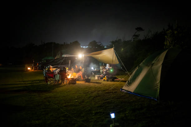 Japanese families camping at night, enjoying dinner