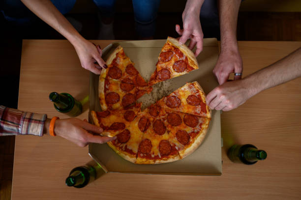 istock Unrecognizable people's hands each grabbing a slice of pizza 1327003394