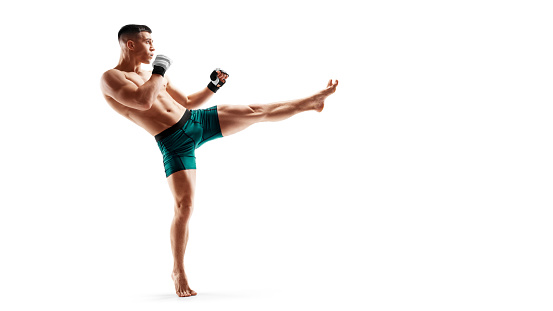 MMA kick. Sport concept. MMA fighter isolated on white background. Athlete. Side view. Men