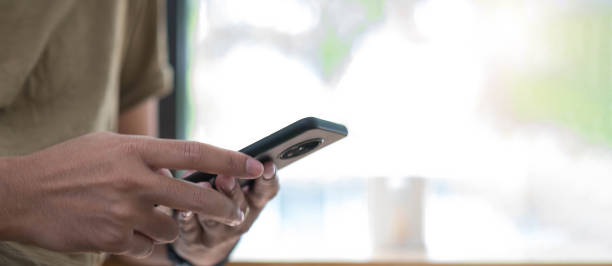istock young man holding smartphone in comfortable workplace near the windows 1327014757