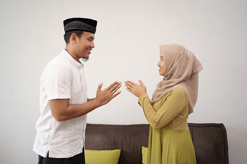 man and woman shake hand muslim touching apologizing on eid mubarak