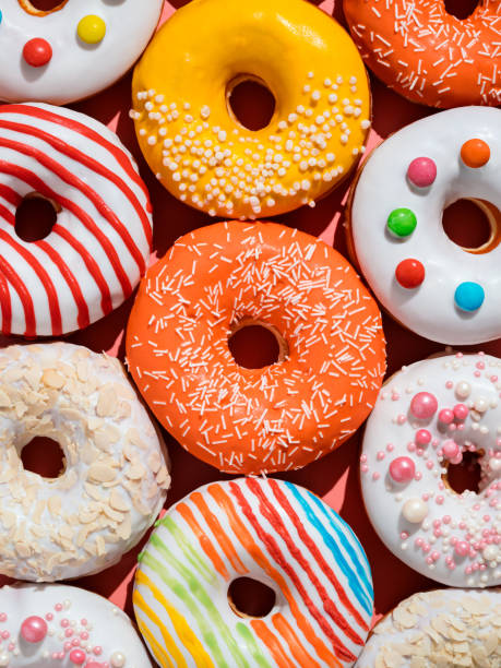 Glazed colorful donuts background, top view