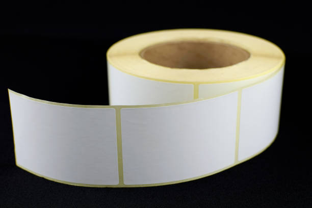 istock Babina of self-adhesive stickers on a black background. Self-adhesive white label roller for printing or manufacturing. 1327019182