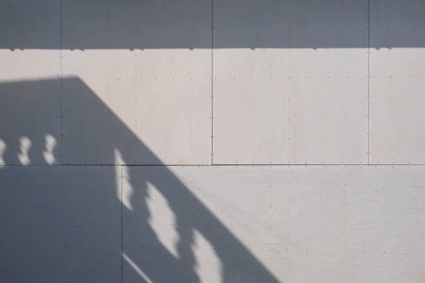 Sunlight and balcony shadow on surface of gray gypsum wall background