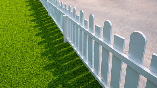piquete de madera blanca con césped artificial verde en el área del patio delantero photo