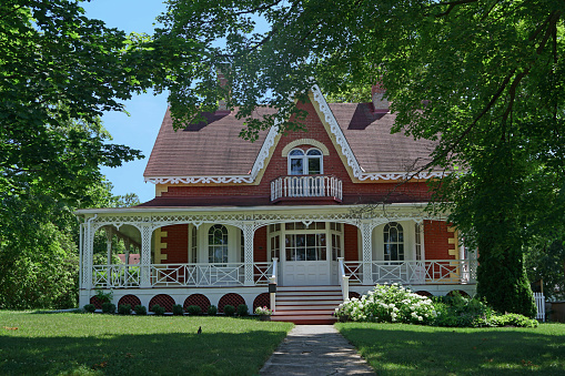 Peterborough, Ontario, Canada - July 4, 2021:  Elegant 19th century heritage house in a small town, with elaborate detailing in the porch enclosure