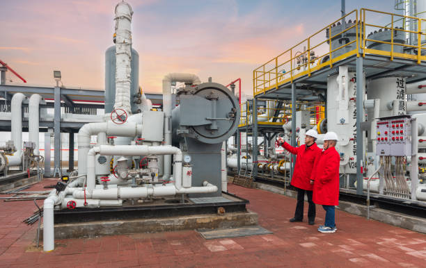 engineers and staff communicate on site in chemical plant - valve chemical plant oil industry imagens e fotografias de stock