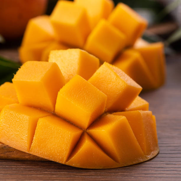 istock Mango. Fresh mango fruit with leaves over dark wooden table background. 1327036752