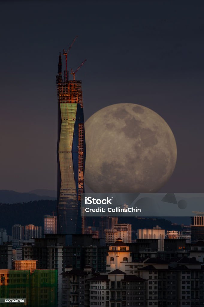 Moon Rising Moon rising during sunset City Stock Photo