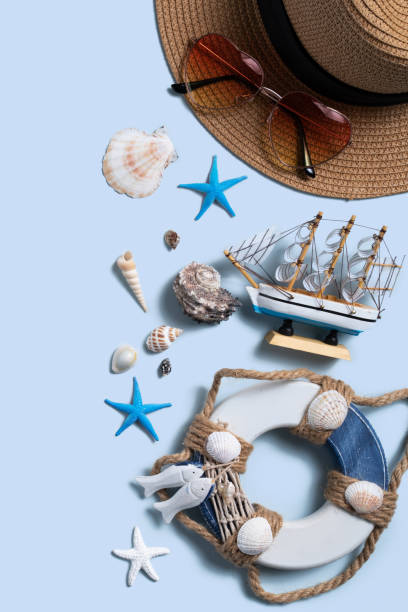 istock Summer beach background design concept with shells, hat, sunglasses on blue background. 1327037658