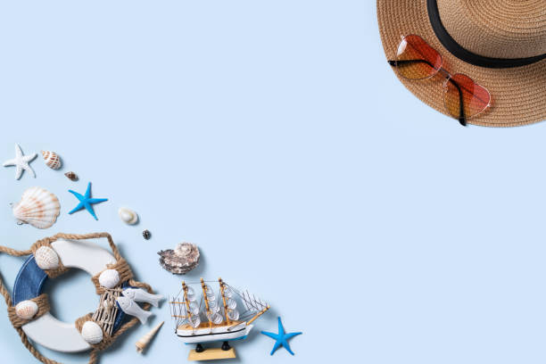 istock Summer beach background design concept with shells, hat, sunglasses on blue background. 1327037686