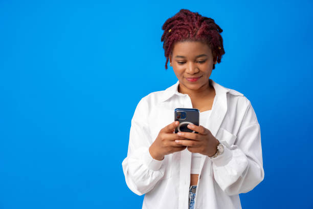 istock African american woman using smartphone against blue background 1327038908
