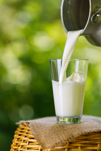 istock milk pouring from metal can into glass 1327041536