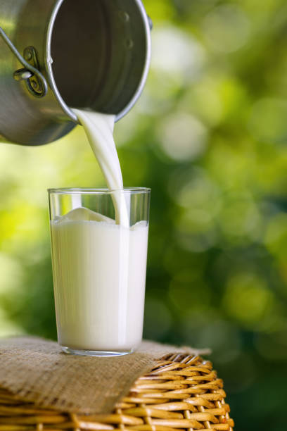istock milk pouring from metal can into glass 1327041541