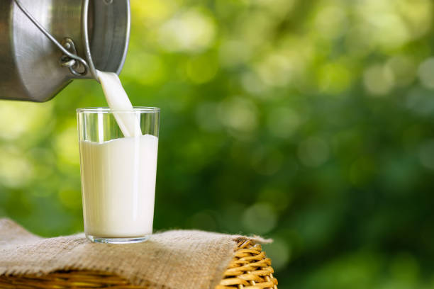 istock milk pouring from metal can into glass 1327041562