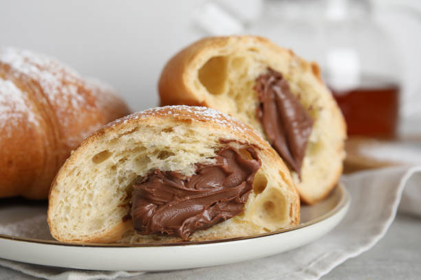 tasty croissants with chocolate and sugar powder on plate, closeup - powder puff imagens e fotografias de stock