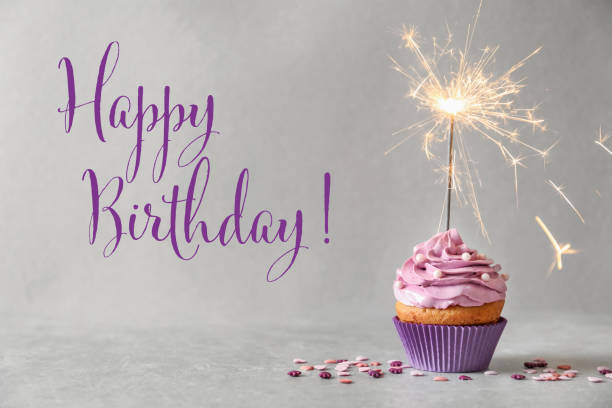 istock Happy Birthday! Delicious cupcake with sparkler on grey background 1327041637