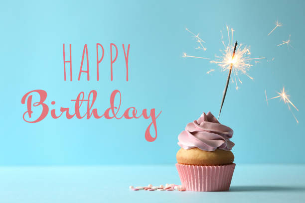 istock Happy Birthday! Delicious cupcake with burning sparkler on blue background 1327042899