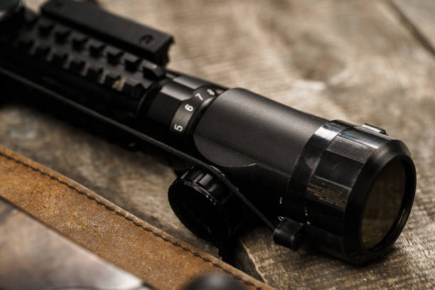 istock The optical sight and shotgun on wooden backgorund 1327043155