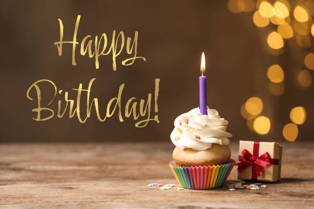 お誕生日おめでとう！木製のテーブルにキャンドルとギフトボックスを備えたおいしいカップケーキ - cupcake sprinkles baking baked ストックフォトと画像