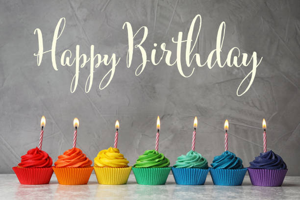 istock Happy Birthday! Delicious cupcakes with burning candles on table 1327043861