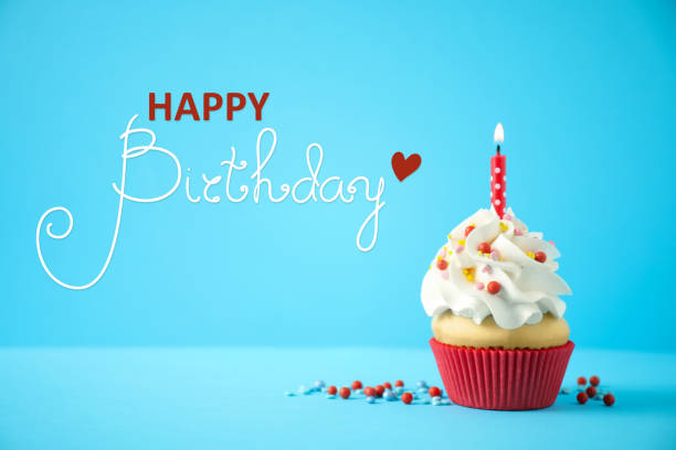 istock Happy Birthday! Delicious cupcake with candle on light blue background 1327043868