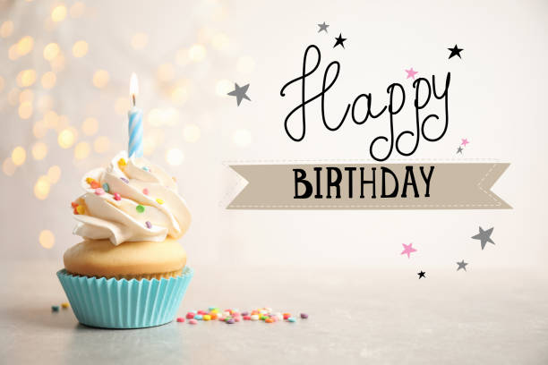 istock Happy Birthday! Delicious cupcake with candle on light table 1327043944
